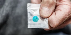 What drug is blues? An image of a man with a fake M30 percocet in a small bag